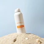 Spray After Sun doTERRA 170g — frasco na areia com conchas, fundo azul pastel, aromaterapia, cuidado da pele