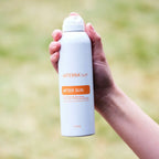 Spray After Sun doTERRA 170g — mão a segurar frasco com fundo de erva verde, hidratação natural
