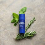 Barra Deep Blue® Copaiba doTERRA — com hortelã e alecrim sobre pedra, vista zenital, óleo essencial CPTG