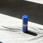 Barra Deep Blue® Copaiba doTERRA — sobre superfície de pedra com sombras e luz solar, alívio muscular