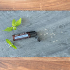 Bolinhas Hortelã-Pimenta Beadlets doTERRA — sobre ardósia cinzenta com folhas de hortelã, vista zenital, óleo essencial CPTG