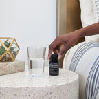 Cápsulas Moles CP+ doTERRA — mesa terrazzo com vaso e mão, lifestyle, suplemento de ácidos gordos essenciais