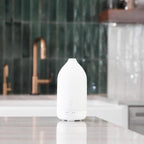 Difusor Laluz doTERRA branco — cozinha com mármore torneira cobre e azulejos verdes, aromaterapia