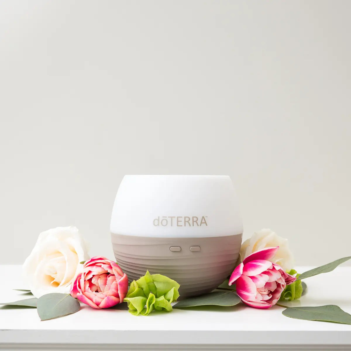 Difusor Pétala 2.0 doTERRA — com flores rosas brancas fundo claro, aromaterapia, difusor ultrassónico