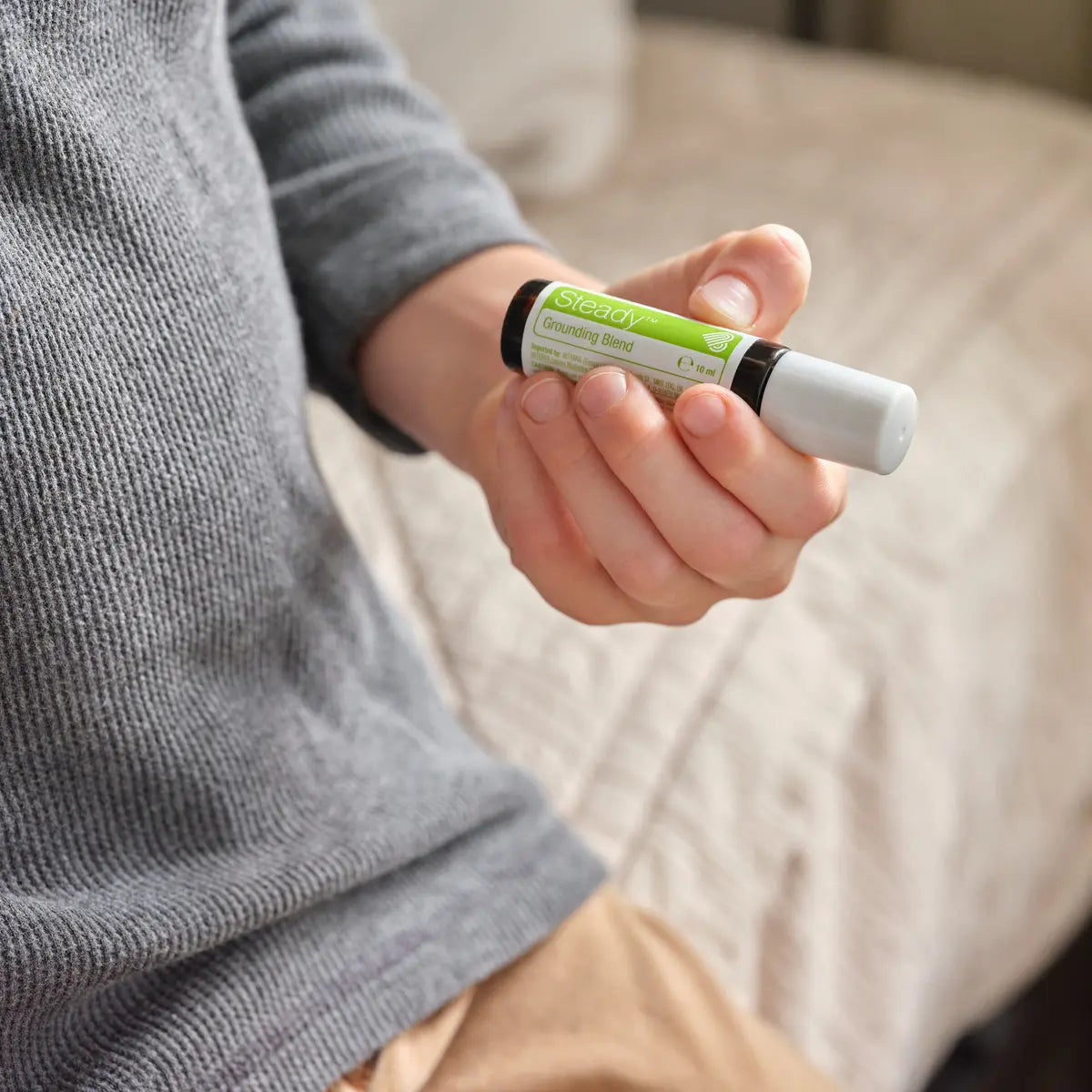 Steady doTERRA 10ml roll-on — mão de menino segurando frasco, mistura de enraizamento para crianças, óleo essencial puro CPTG