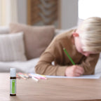 Steady doTERRA 10ml roll-on — menino estudando com frasco em mesa, mistura de enraizamento para crianças, óleo essencial puro CPTG