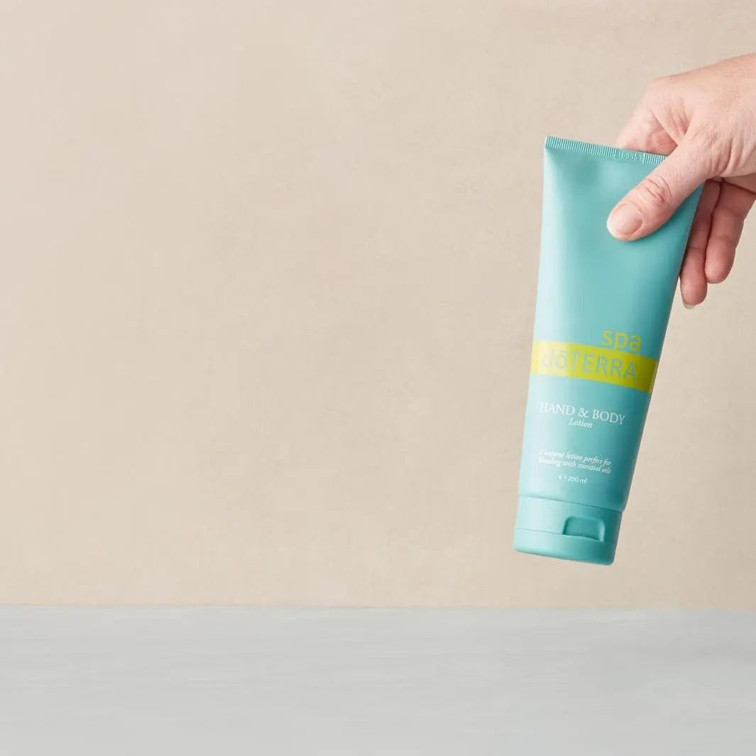 Loção Corpo e Mãos SPA doTERRA — mão a recolher o frasco, hidratação corporal natural CPTG