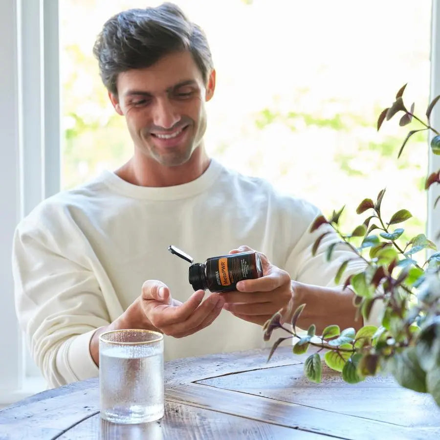 MetaPWR Mito2Max doTERRA 60 cápsulas — homem sorrindo à mesa de madeira com cápsulas, suplemento natural de energia