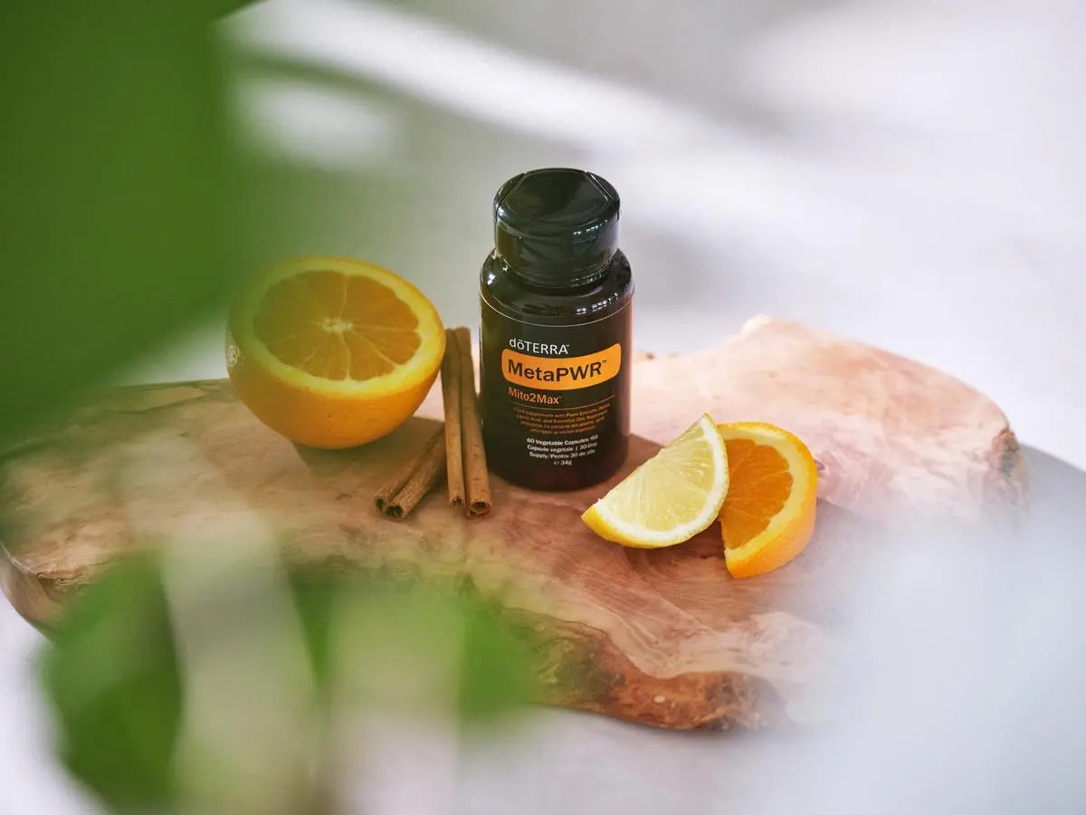 MetaPWR Mito2Max doTERRA 60 cápsulas — frasco sobre rodela de madeira com citrinos, canela e limão, complexo energético natural