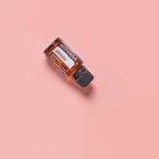 Mistura Abode doTERRA 15ml — frasco inclinado sobre fundo rosa coral, óleo essencial puro CPTG