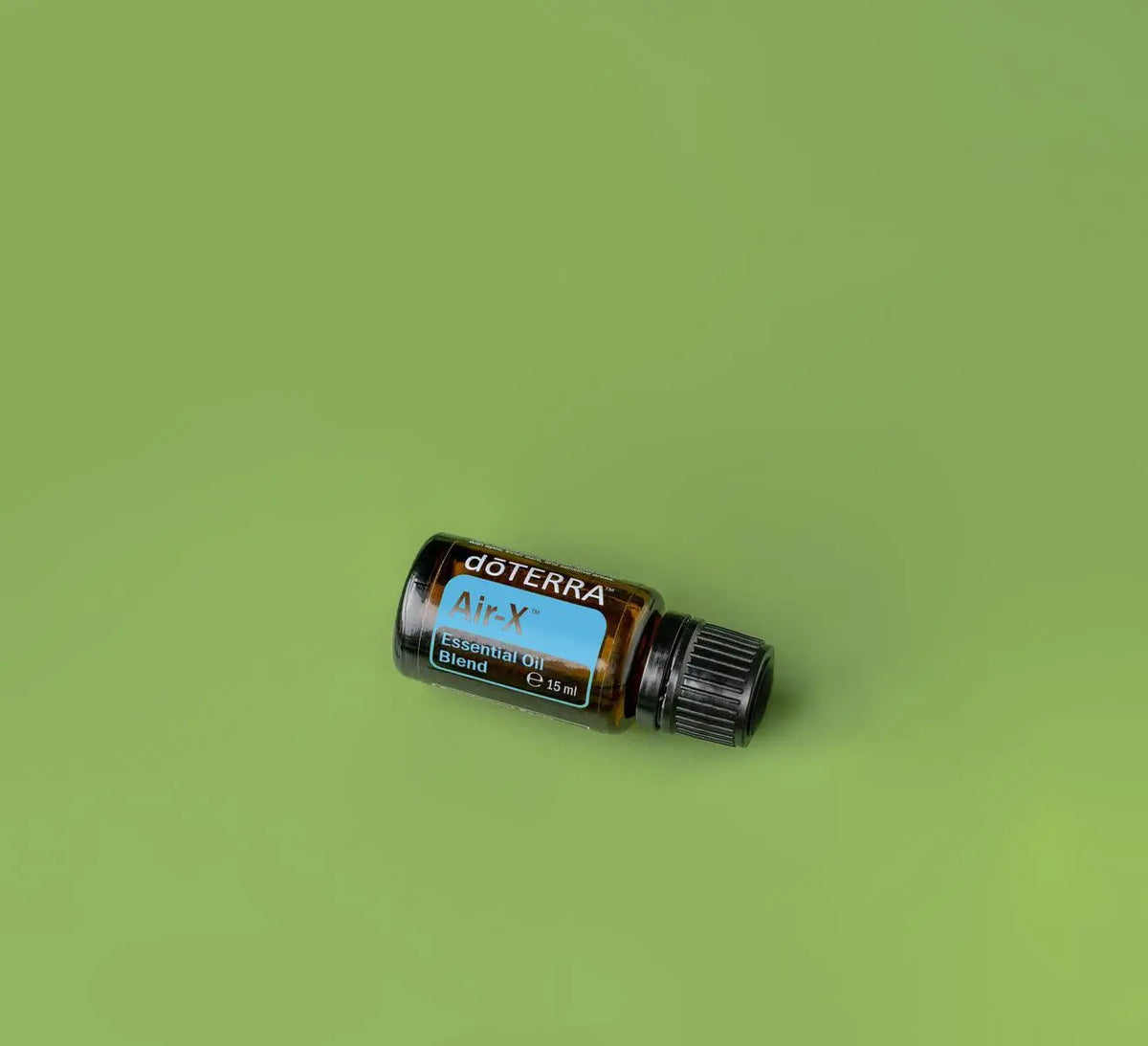 Mistura Air doTERRA 15ml — frasco inclinado em fundo verde-oliva, vista zenital, óleo essencial respiratório CPTG