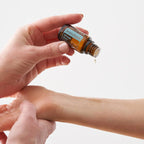 AromaTouch doTERRA 15ml mãos aplicando gota pulso massagem fundo branco, aromaterapia tãctil