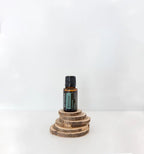 Balance doTERRA 15ml frasco ródelas madeira empilhadas fundo branco, equilíbrio natural