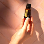 Citrus Bliss doTERRA 15ml mão segurando frasco chão mosaico terracota sol, aromaterapia