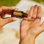 Citrus Bliss doTERRA 15ml mãos colocando gota palma exterior bokeh verde, frescura natural