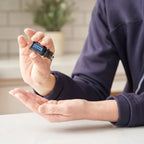 Deep Blue doTERRA 5ml pessoa fato azul aplicando gota palma cozinha, massagem muscular natural