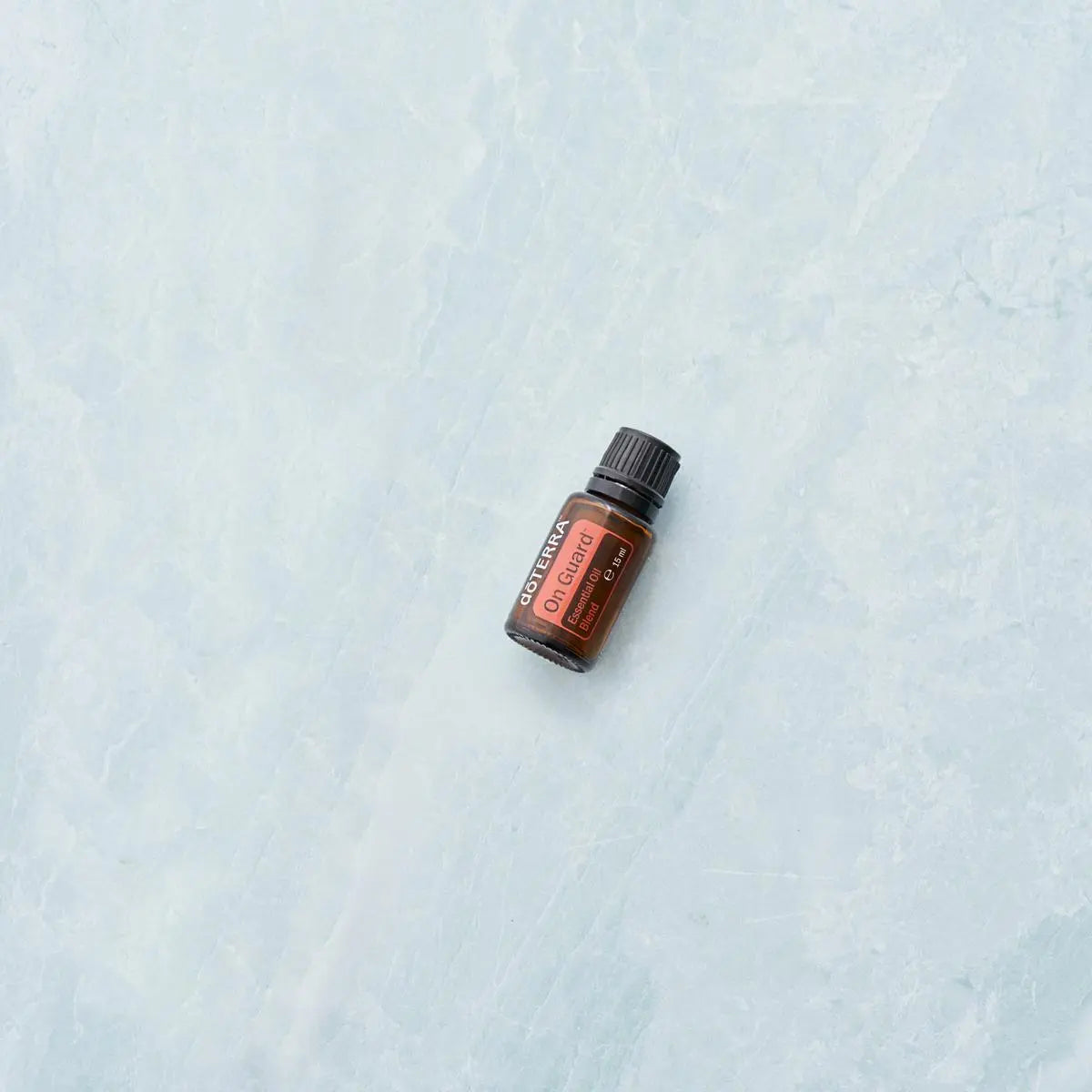 On Guard doTERRA 15ml frasco deitado mármore azul claro zenital minimalista, óleo essencial protetor