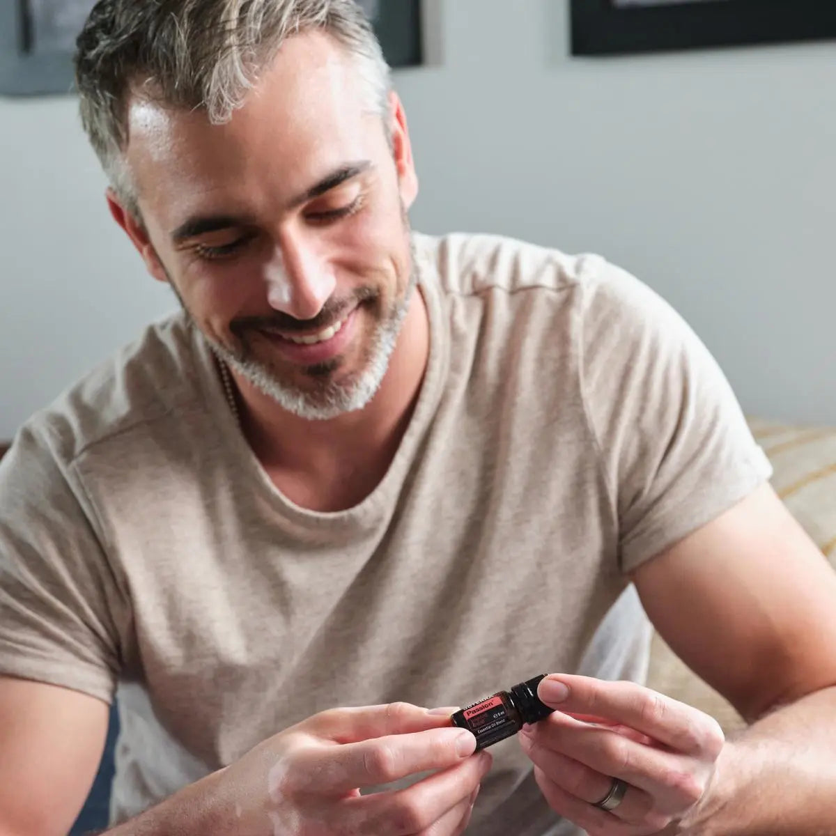 Passion doTERRA 5ml homem cabelo grisalho segurando frasco duas mãos sala, romance equilíbrio óleo essencial CPTG