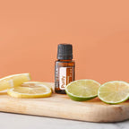 Mistura Purify doTERRA 15ml — tábua de madeira com rodelas de limão e lima, fundo laranja pêssego, aromaterapia
