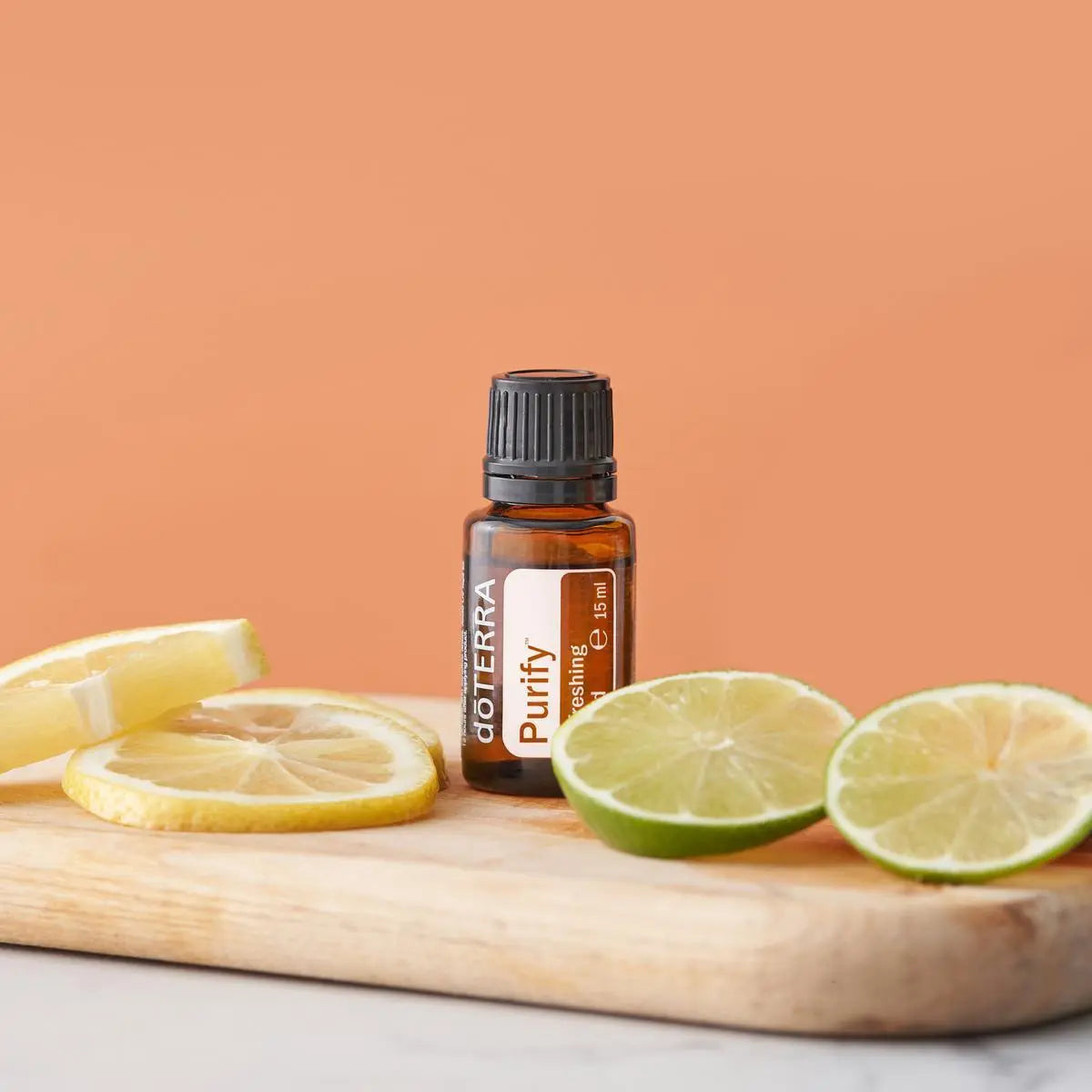 Mistura Purify doTERRA 15ml — tábua de madeira com rodelas de limão e lima, fundo laranja pêssego, aromaterapia