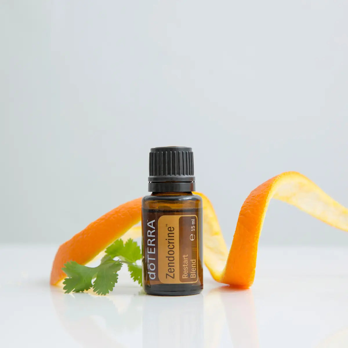 Zendocrine doTERRA 15ml — frasco em espiral com pele de laranja e coentro, fundo branco, óleo essencial puro CPTG