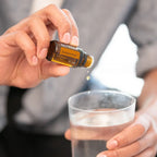 Zendocrine doTERRA 15ml — mãos colocando gota em vaso com água e gelo, primeiro plano, óleo essencial purificante