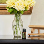 Óleo Essencial Árvore do Chá doTERRA 15ml — frasco em consola preta com rosas amarelas e jarro, óleo essencial CPTG puro, aromaterapia