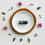 Óleo Essencial Baga de Zimbro doTERRA 5ml — prato e bandeja de madeira com flores lilás, vista zenital, CPTG puro