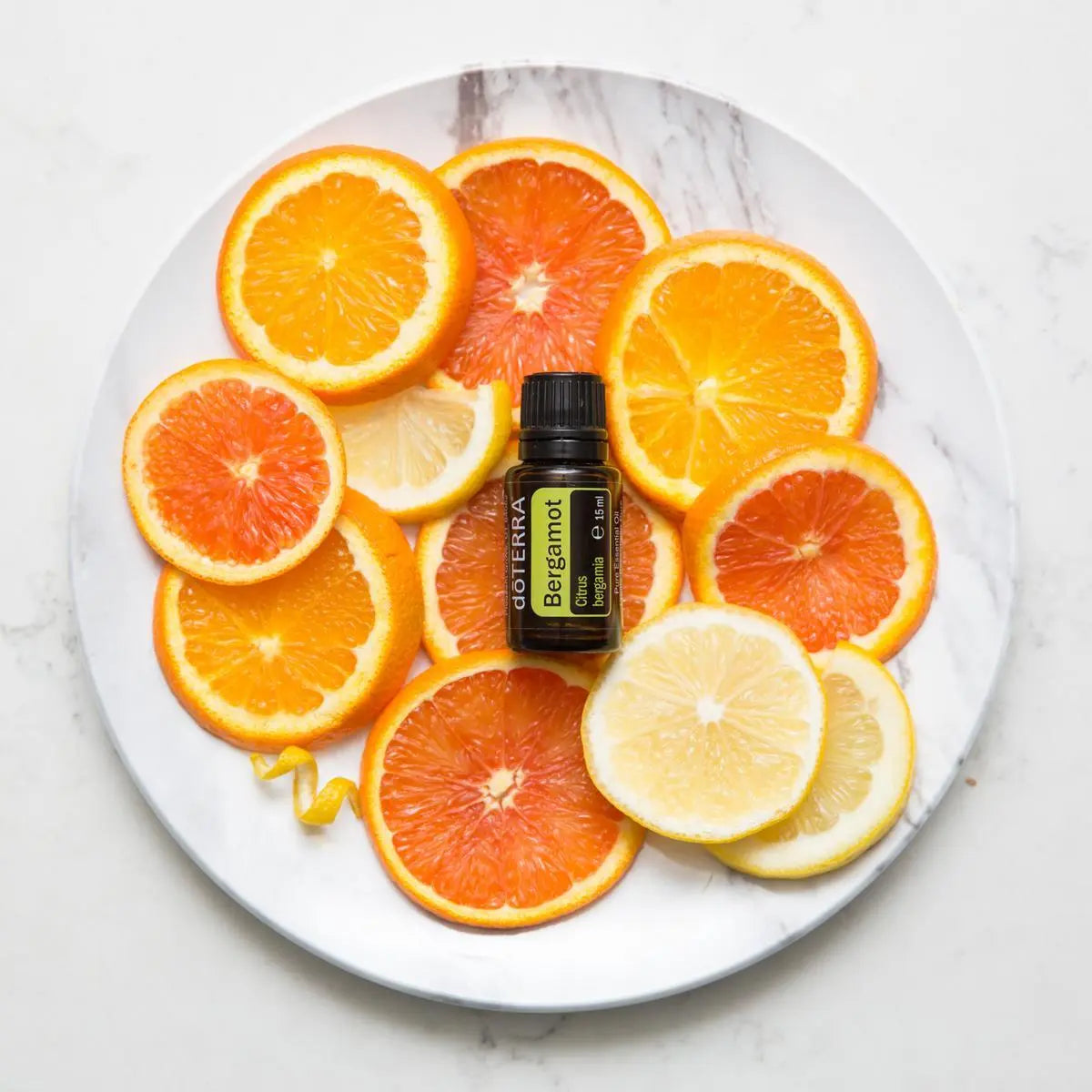 Óleo Essencial Bergamota doTERRA 15ml — prato de mármore com citrinos, laranja e toranja, aromaterapia CPTG