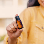 Óleo Essencial Cássia doTERRA 15ml — mulher com casaco amarelo no exterior, uso quotidiano, bem-estar natural