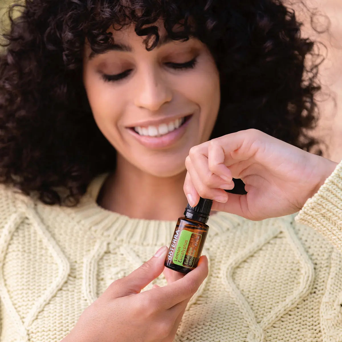 Óleo Essencial Eucalipto Limão doTERRA 15ml — mulher cabelo encaracolado camisola creme sorrindo
