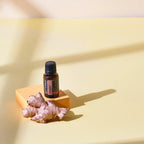 Óleo Essencial Gengibre doTERRA 15ml — pedestal laranja com raiz de gengibre fundo amarelo