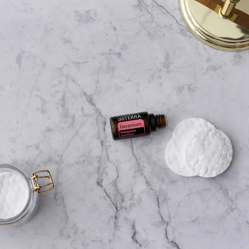 Óleo Essencial Gerânio doTERRA 15ml — sobre mármore com algodão e espelho dourado, bem-estar natural