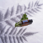 Óleo Essencial Hortelã-Pimenta doTERRA 15ml — raminho de hortelã sobre tecido branco com sombra suave, planta fresca