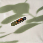Óleo Essencial Incenso doTERRA 15ml — sobre lona creme com sombras de folhas de palmeira, meditação CPTG