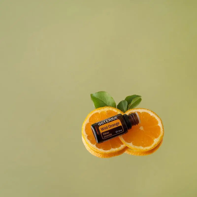Óleo Essencial Laranja Silvestre doTERRA 15ml — rodelas de laranja com folhas em fundo verde, óleo cítrico puro