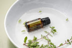 Óleo Essencial Manjerona doTERRA 15ml — frasco sobre tigela branca com raminho de manjerona fresca, aromaterapia, óleo essencial puro CPTG