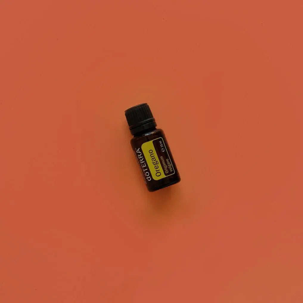Óleo Essencial Orégão doTERRA 15ml — flat lay com frasco sobre fundo terracota, aromaterapia, óleo essencial puro CPTG