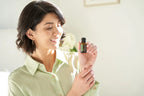 Óleo Essencial de Sálvia Esclareia doTERRA 15ml — mulher morena sorrindo em interior branco com frasco, aromaterapia, óleo essencial puro CPTG