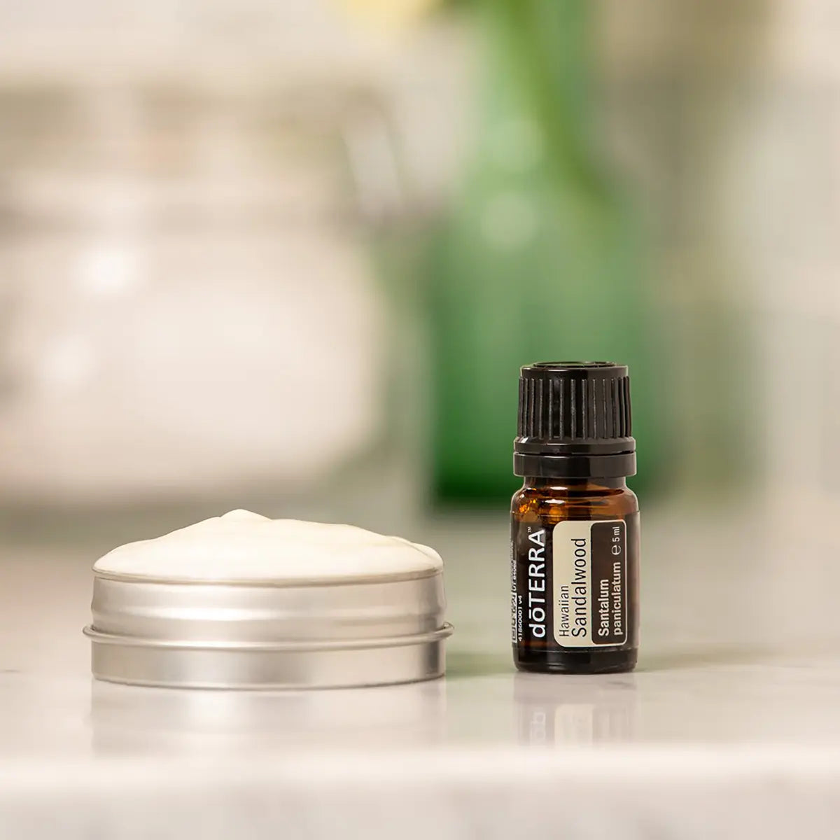 Óleo Essencial Sândalo Havaiano doTERRA 5ml — frasco com creme alumínio em bancada com planta e fundo desfocado, aromaterapia, óleo essencial puro CPTG