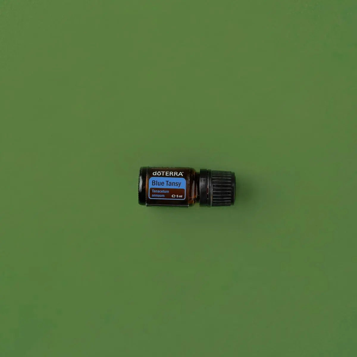 Óleo Essencial Blue Tansy doTERRA 5ml — frasco horizontal em fundo verde oliva minimalista, aromaterapia, óleo essencial puro CPTG