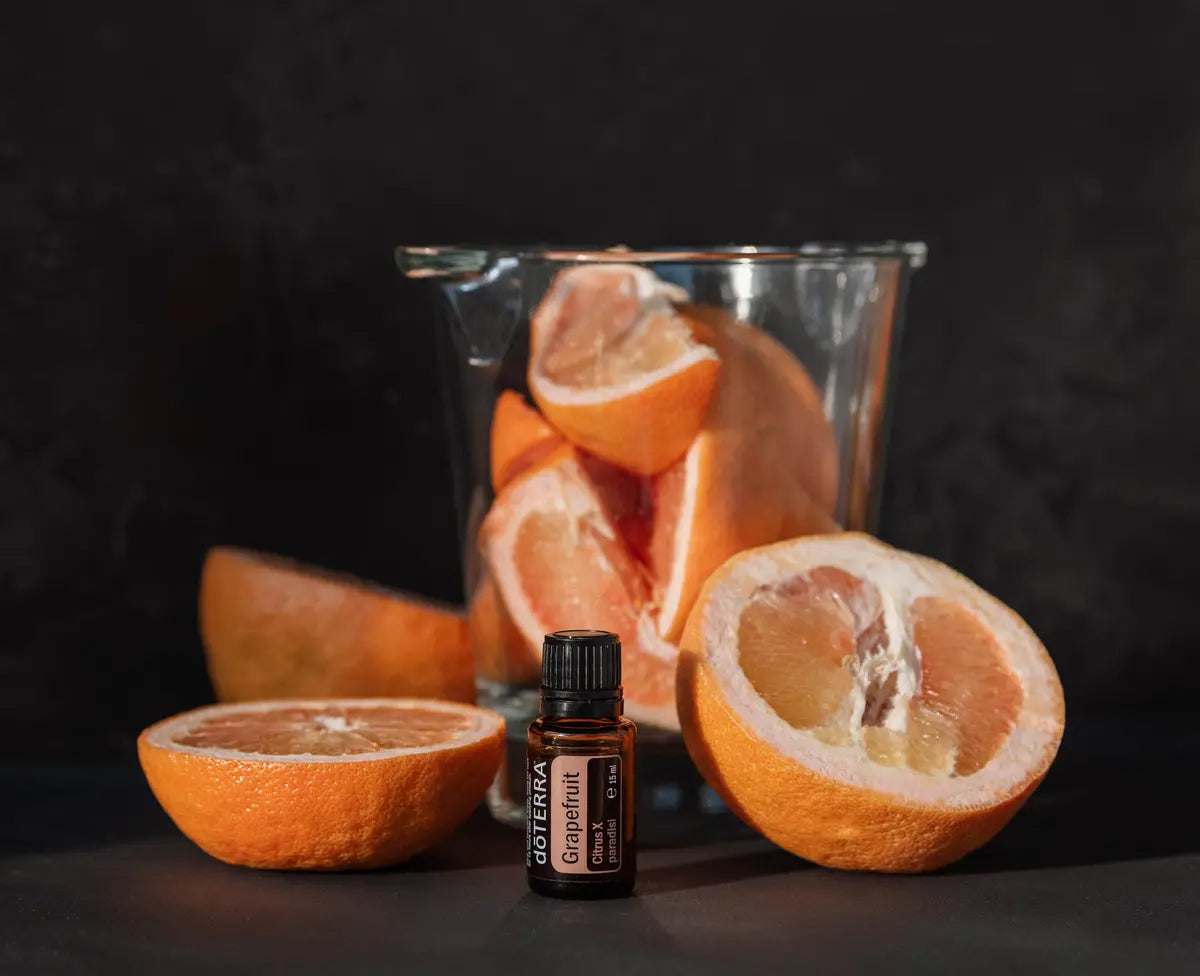 Óleo Essencial de Toranja doTERRA 15ml — metades de toranja, jarro de vidro com gomos em fundo preto, aromaterapia, óleo essencial puro CPTG