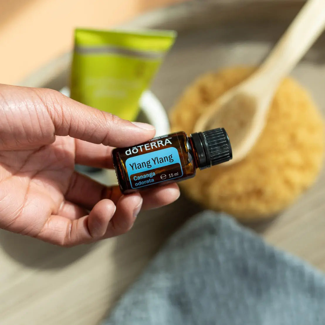 Óleo Essencial de Ylang Ylang doTERRA 15ml — mão com acessórios spa e scrub de açúcar, aromaterapia, óleo essencial puro CPTG
