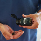PB Restore doTERRA — homem de camisa azul com cápsulas na mão, lifestyle, suplemento microbioma CPTG
