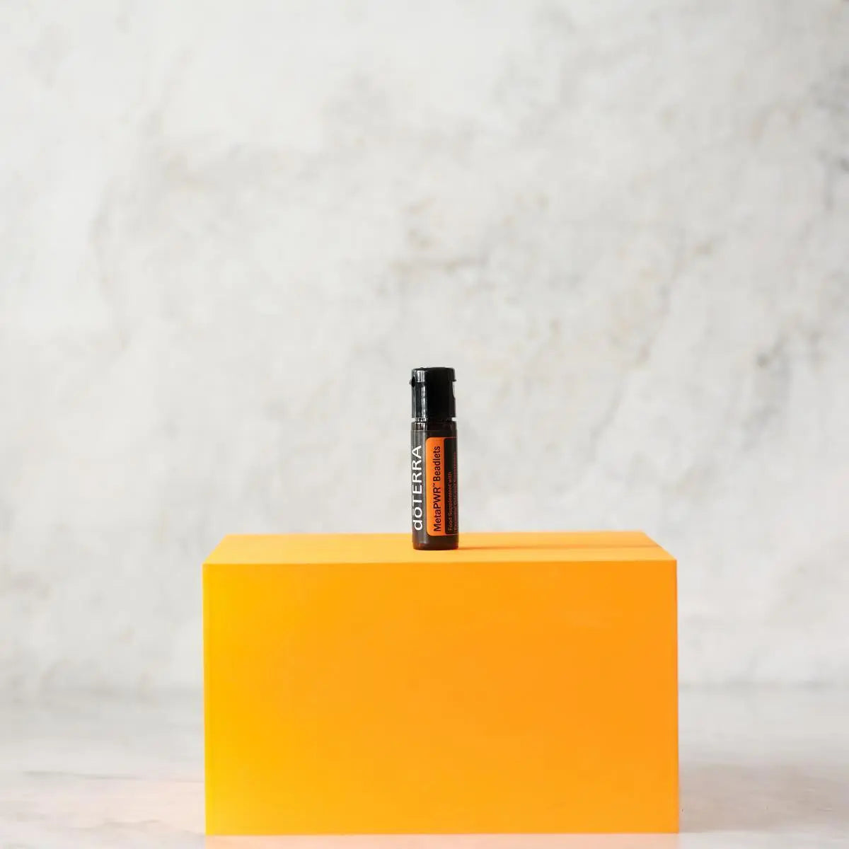 MetaPWR Advantage doTERRA — frasco cubo laranja vibrante, fundo mármore, estúdio, suplemento energia CPTG