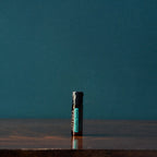 Beadlets Supermint doTERRA — frasco em mesa de madeira escura, fundo verde azulado, menta refrescante puro CPTG