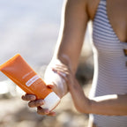 Loção Solar Mineral Rosto+Corpo doTERRA SPF30 — mulher a aplicar no braço na praia, proteção solar natural CPTG