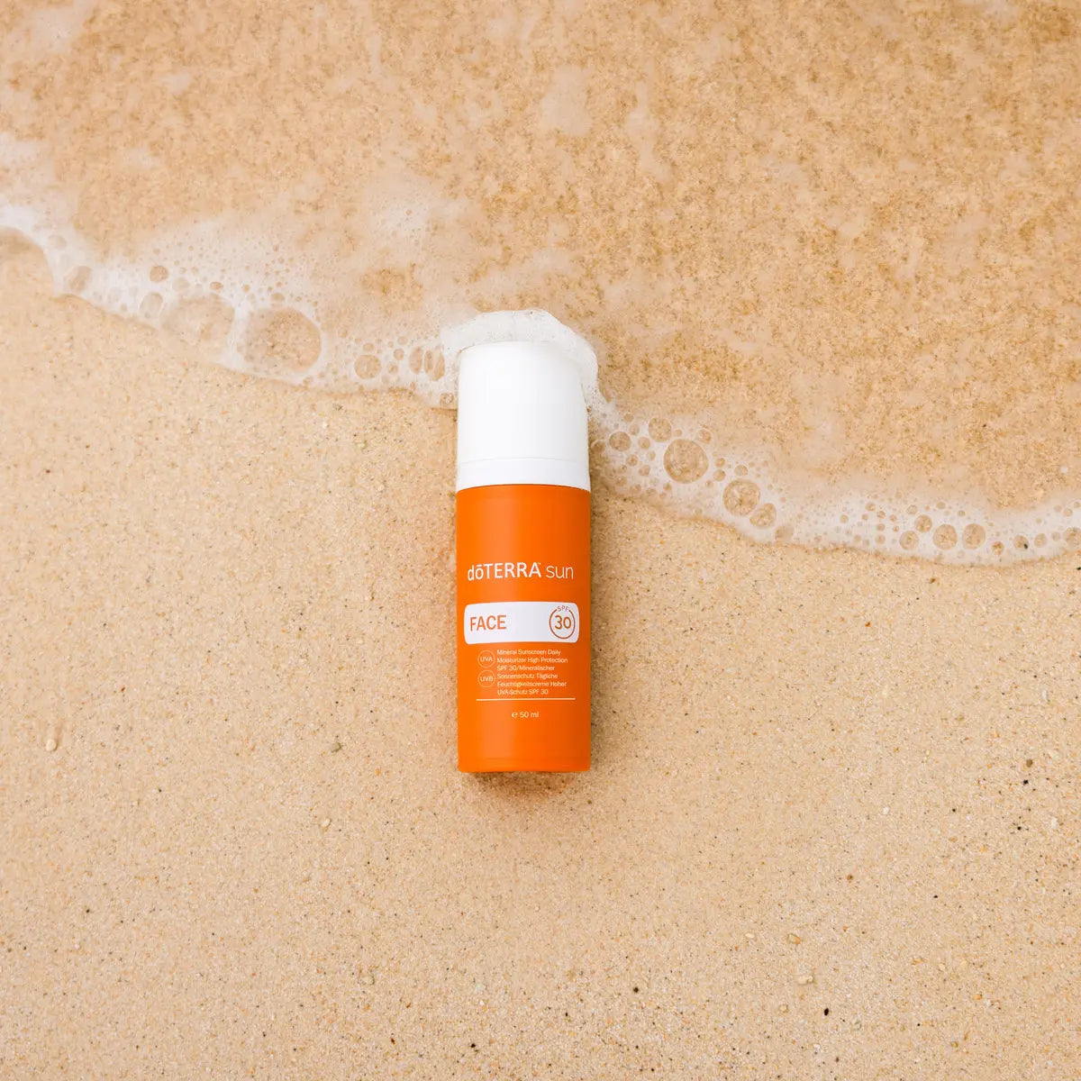 Protetor Solar Mineral Hidratante doTERRA SPF30 — frasco em areia húmida com espuma de onda, cuidado solar natural CPTG