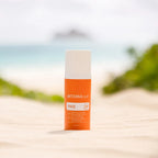 Protetor Solar Mineral Hidratante doTERRA SPF30 — frasco em areia de praia com mar e ilha, proteção facial CPTG