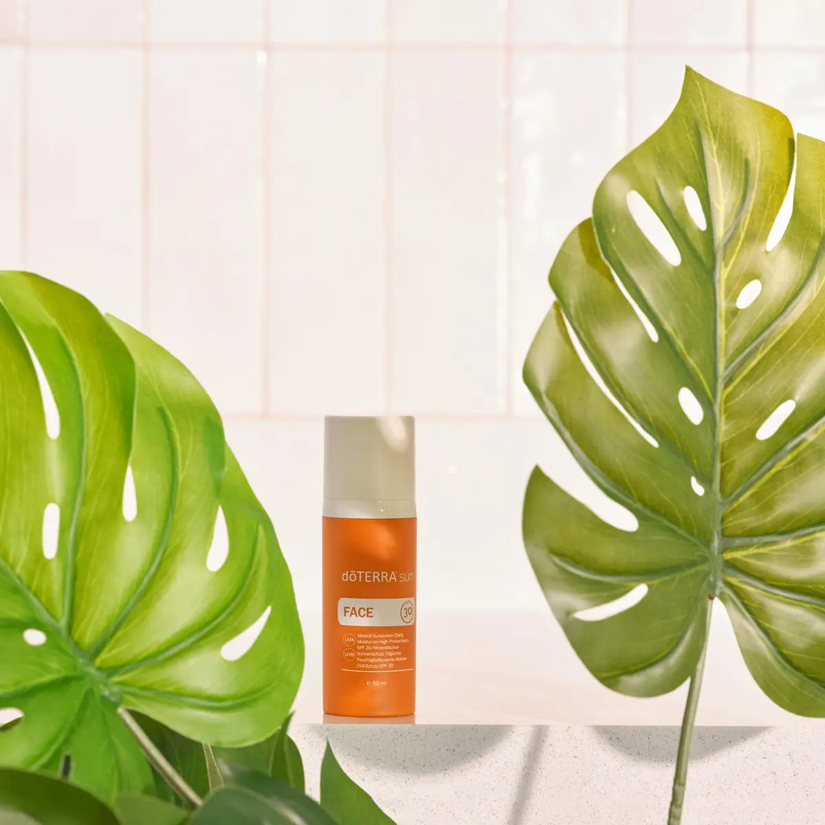 Protetor Solar Mineral Hidratante doTERRA SPF30 — frasco com folhas de monstera em azulejo branco, facial natural CPTG
